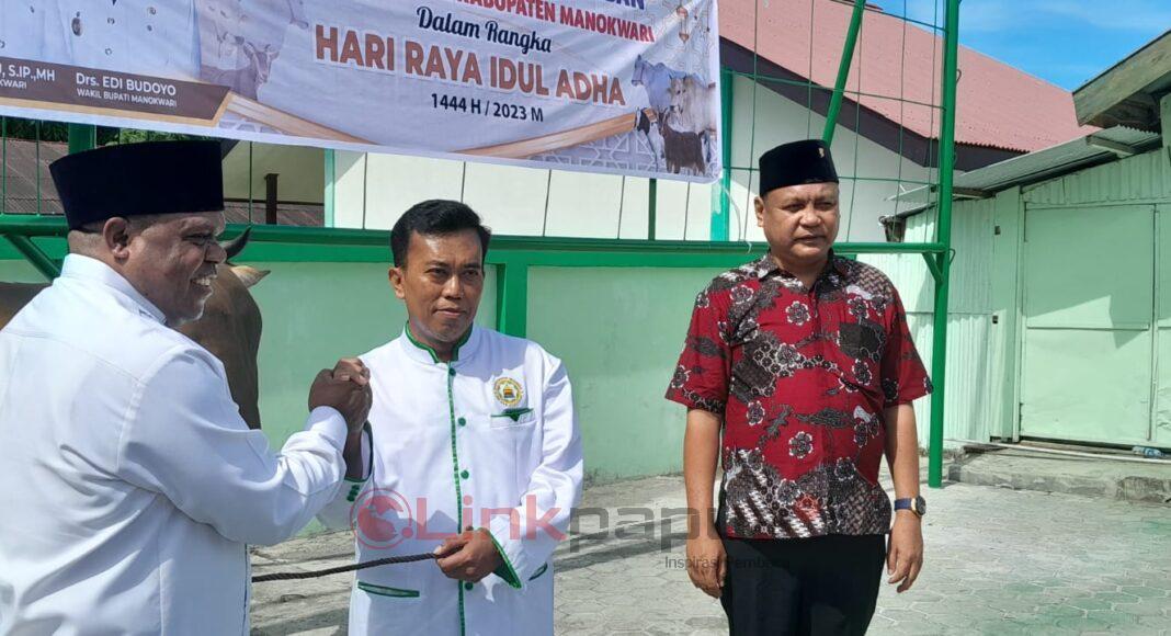 Bupati Manokwari Hermus Indou menyerahkan hewan kurban secara simbolis kepada Ketua Dewan Masjid Indonesia Kabupaten Manokwari, Ustad Zainal