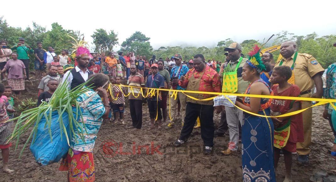 Ketua DPR Papua Barat Orgenes Wonggor memotong pita pada prosesi adat pembukaan ruas jalan Kampung Merpioba-Amber di Distrik Warmare